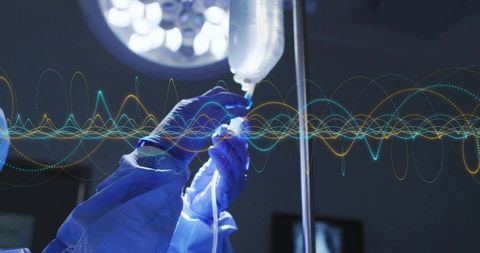 Gloved hands adjusting IV drip under surgical light with waveform overlay