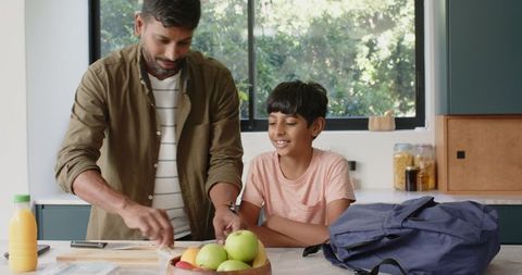 Happy Father Son Duo Preparing Snack Together in Home Kitchen