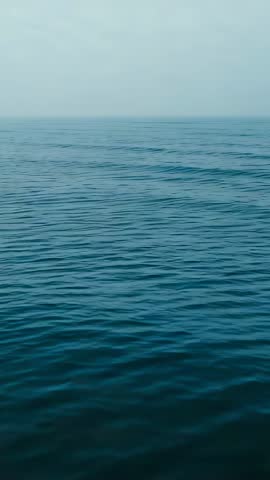 Rippling Open Ocean Surface Moving Under Light Wind with Horizon and Mist Vertical Video