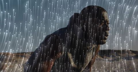 Determined Athlete Under Virtual Rainfall in Desert Landscape