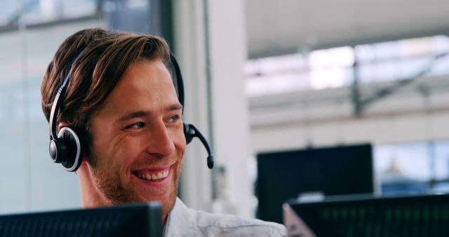 Smiling male customer service executive working in a call centre