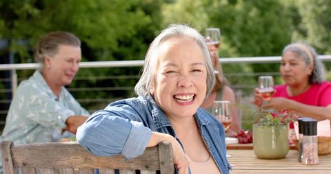 Smiling Senior Friends Enjoy Outdoor Gathering with Wine