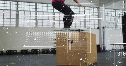 Female athlete performing plyometric box jump with hud metrics in industrial gym