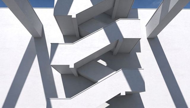 White concrete zigzag staircase casting angular shadows across sunlit exterior wall