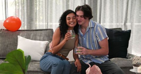 Couple Celebrating Birthday Toasting in Cozy Living Room
