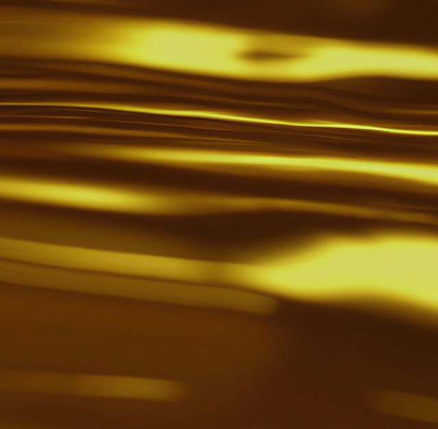 Elegant and luxurious close-up of shiny golden surface. Ideal for backgrounds, wallpapers, and design elements in themes related to luxury, wealth, and premium products. Perfect for use in advertisements, website banners, or print materials to convey a sense of richness and sophistication.