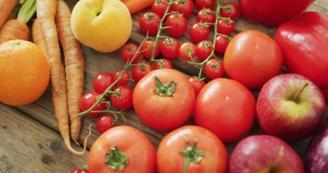 Displaying Fresh Red Tomatoes, Cherry Vine, Apples and Carrots on Rustic Wood