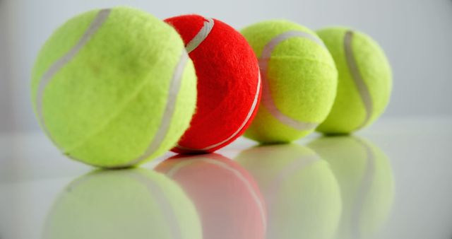 Four Tennis Balls in a Row with One Bright Red - Download Free Stock Images Pikwizard.com