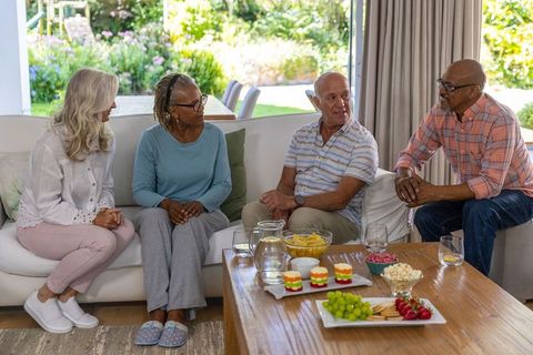 Senior friends chatting around cozy living room atmosphere