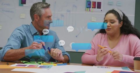 Creative team collaborating on color swatches and mockups, selecting palette at whiteboard