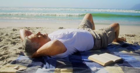 Senior Man Relaxing on Serene Beach with Book - Download Free Stock Images Pikwizard.com
