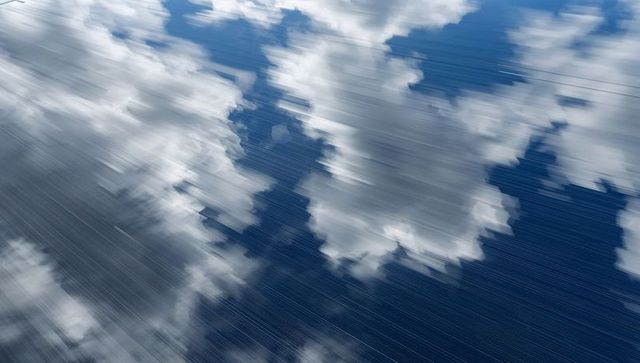Cumulus cloud bank drifting over deep blue ocean with diagonal rain streaks, storm motion