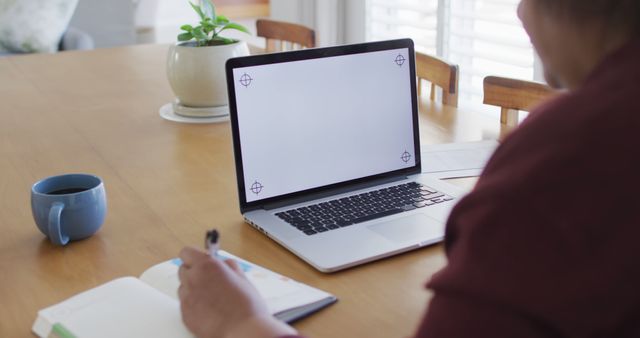 Person Working at Home with Laptop and Notebook on Wooden Table - Download Free Stock Images Pikwizard.com