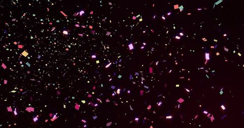 Swirling neon confetti scattering across black backdrop, iridescent glitter for celebration