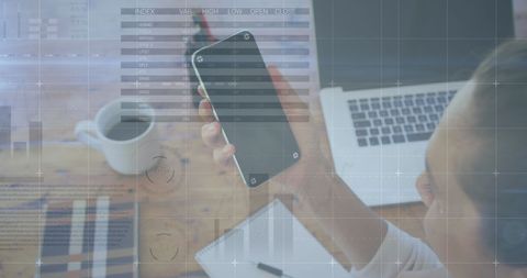 Businesswoman Analyzing Financial Data on Smartphone with Laptop Nearby - Download Free Stock Images Pikwizard.com