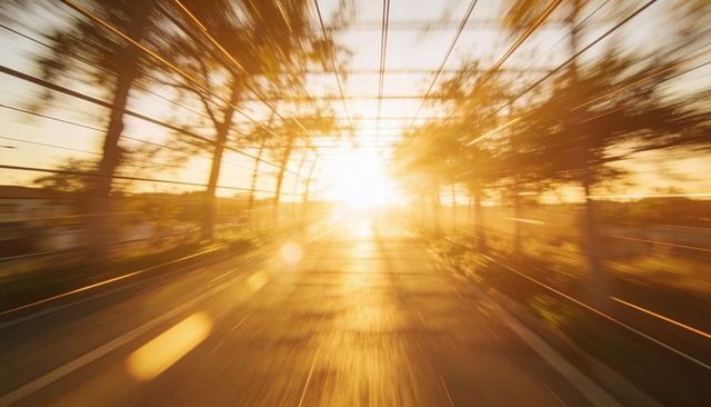 Blazing sunburst through trellised bridge tunnel during golden hour motion streaks lens flare