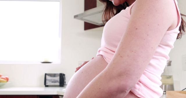 Pregnant Woman Touching Her Belly in Modern Kitchen - Download Free Stock Images Pikwizard.com