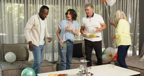 Diverse Coworkers Bonding at Office Party Clean-up Session