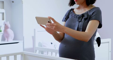 Pregnant Woman Using Tablet in Nursery Setting - Download Free Stock Images Pikwizard.com