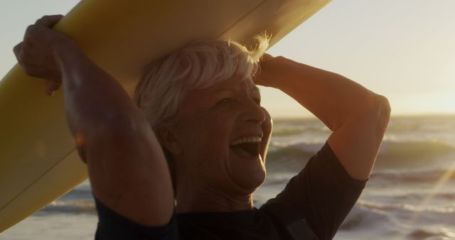 Joyful Senior Woman Carrying Surfboard at Sunset Beach - Download Free Stock Images Pikwizard.com