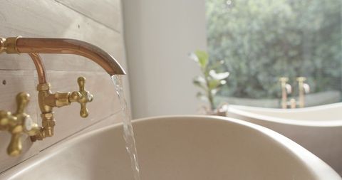 Close-Up of Brass Washbasin with Flowing Water in Rustic Bathroom - Download Free Stock Images Pikwizard.com