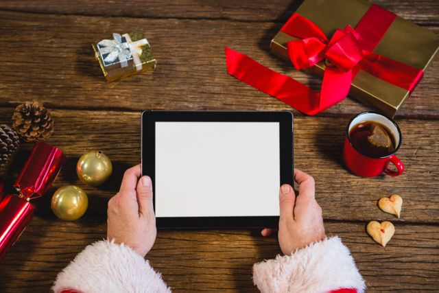 Hands of Santa Claus holding digital tablet