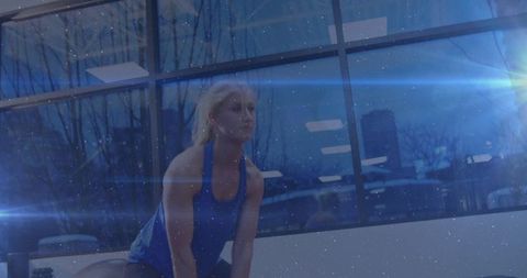 Caucasian Woman Lifting Kettlebell in Gym with Dynamic Blue Light Effects
