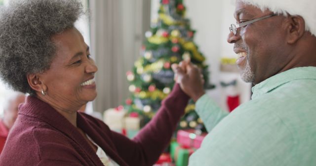 Joyful Elderly Couple Dancing Together by Christmas Tree - Download Free Stock Images Pikwizard.com