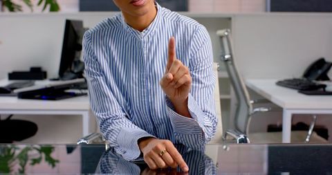 Businesswoman in Striped Shirt Discussing Strategy at Desk