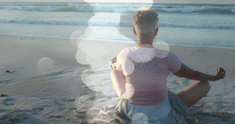 Senior Woman Meditating on Tranquil Beach at Sunrise - Download Free Stock Images Pikwizard.com