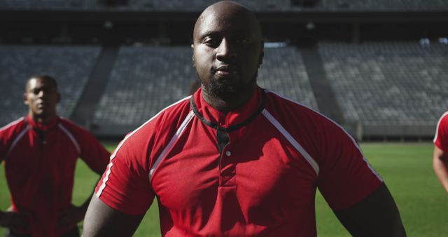 Confident rugby player in red jersey standing on stadium field - Download Free Stock Images Pikwizard.com