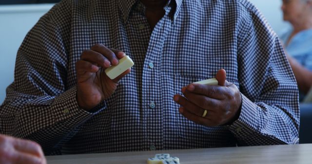 Senior African American Man Playing Dominoes in Casual Setting - Download Free Stock Images Pikwizard.com