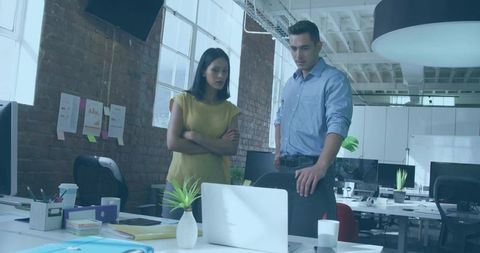 Team Collaborating Over Laptop in Modern Office Environment