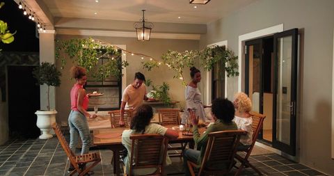 Friends Cleaning Up After Outdoor Dinner Party Celebration