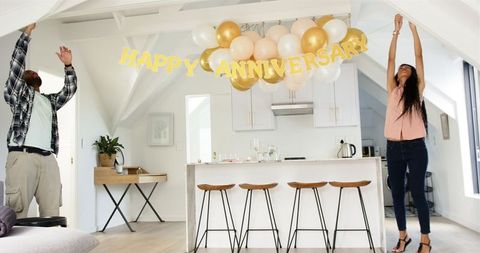 Couple Taking Down Anniversary Party Decorations in Kitchen