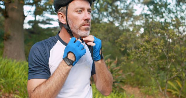 Adult Cyclist Adjusting Helmet Straps in Outdoor Park - Download Free Stock Images Pikwizard.com