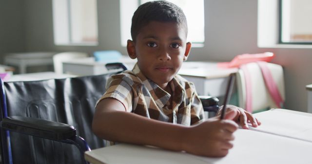 Focused Young Boy in Wheelchair Writing in Classroom - Download Free Stock Images Pikwizard.com