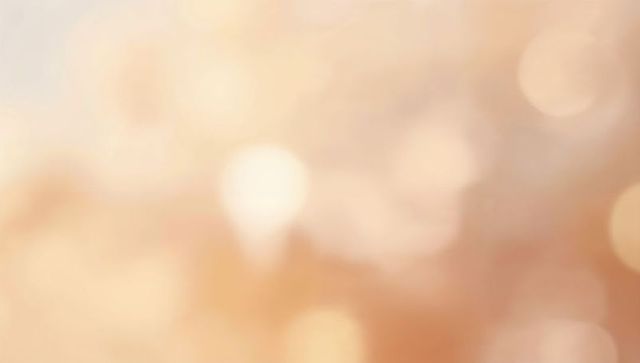 Peach and pale gold bokeh backdrop creating dreamy ethereal glow with soft orb highlights