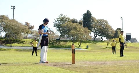 Cricketer Preparing to Bat on Sunny Day Outdoors