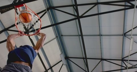 Basketball Player Dunking Ball in Indoor Gymnasium