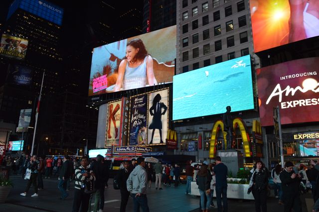 Times Square is busy with crowds against the backdrop of various illuminated billboards at night. This image captures the vibrant essence of New York City's nightlife and culture, making it ideal for advertising, travel blogs, urban lifestyle articles, and content about iconic city landmarks.