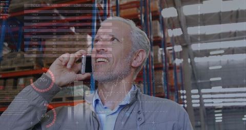 Warehouse manager talking on phone with data overlay in modern logistics and inventory hub
