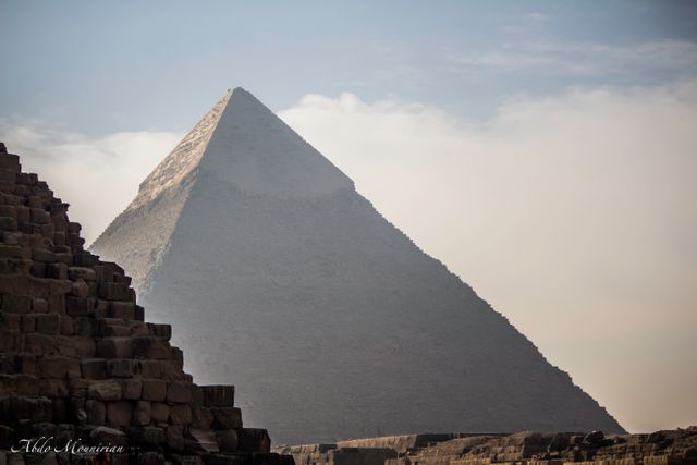 The Great Pyramid of Giza stands tall against a clear sky, exhibiting marvels of ancient Egypt. The image showcases the pyramid's grandeur and ancient architectural brilliance. Ideal for use in travel blogs, educational materials on Egyptian history, promotion of tourism to Egypt, and cultural heritage projects.