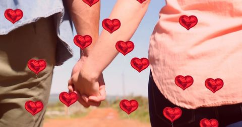 Romantic couple holding hands with heart balloons