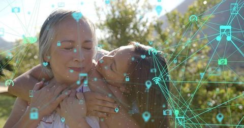Grandmother and granddaughter hugging in sunlit garden with teal digital network overlay