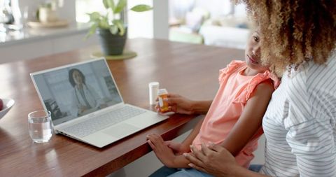 Mother daughter virtual consultation with doctor on laptop