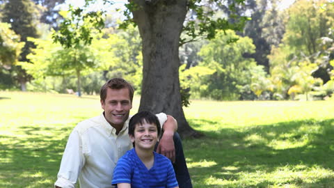 Father and Son Smiling Together in Sunny Park