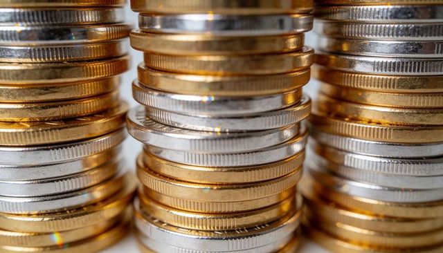 Shining bimetal coin stacks reflecting light closeup for finance and investment design