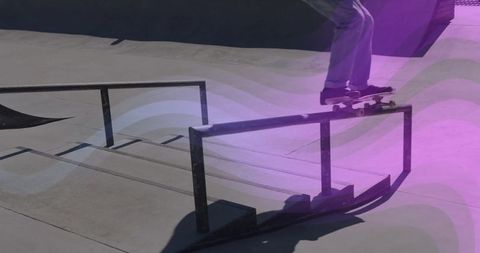 Skateboarder grinding rail with purple light trails in urban skate park