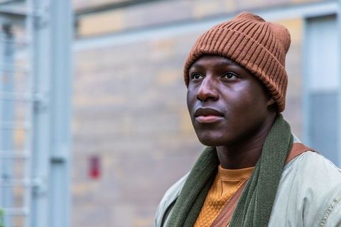 African american man wearing beanie and scarf looking thoughtful in urban casual portrait